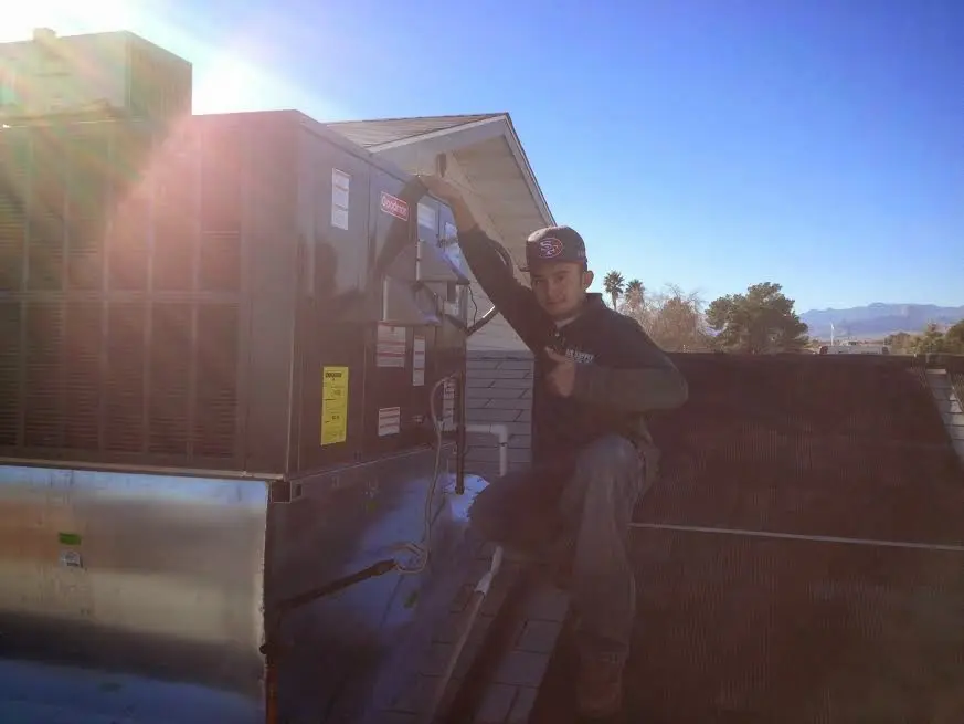 HVAC technician performing AC Tune-Up on a rooftop unit in Indian River Estates
