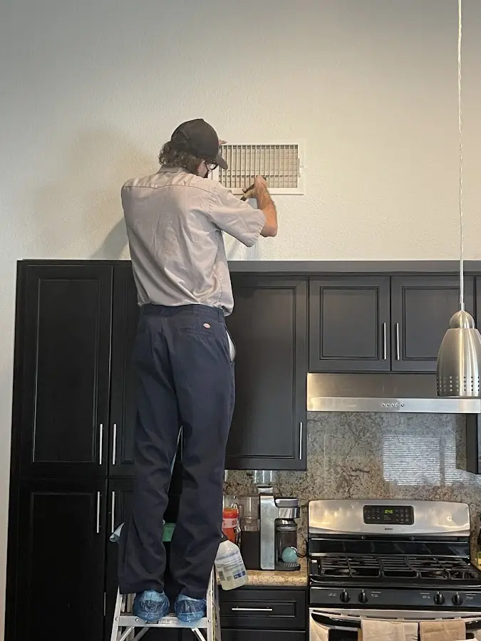 Technician inspecting an air vent during HVAC service in Indian River Estates